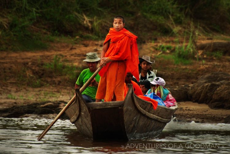 A monk heading up a boat on the Mekong River in Laos