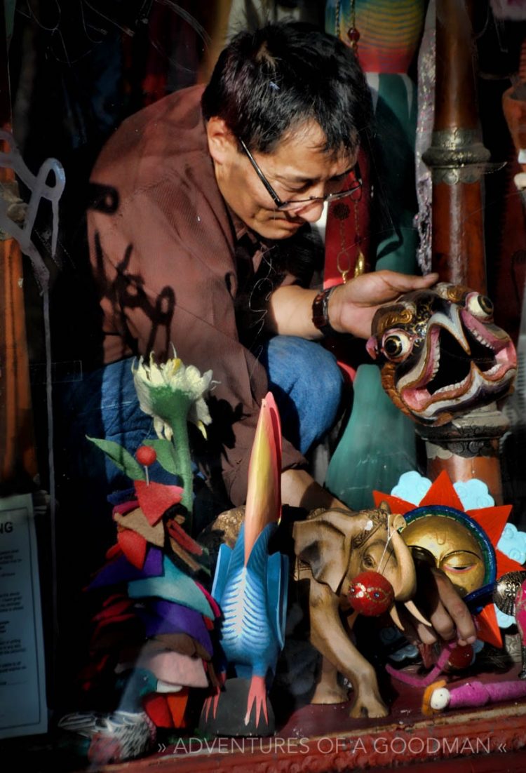 A local merchant places colorful products in his window on the corner of Haight and Clayton