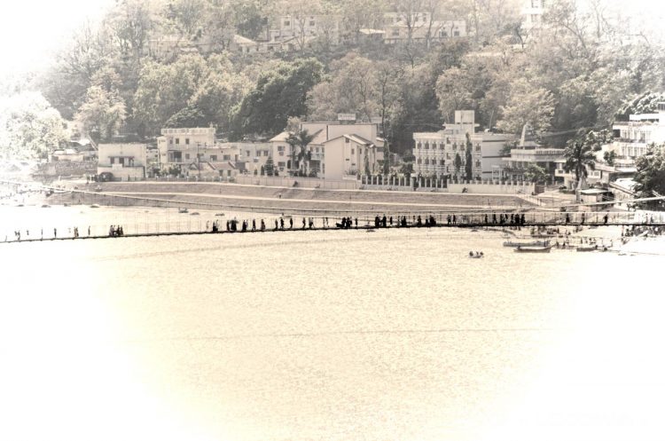 A photo of people walking across the Ram Jhula bridge on a sunny day. I had a blast in Photoshop creating the blown-out, old-time look.