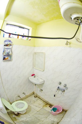 The bathroom of the River View Cottages, with the power line for the water heater hanging above