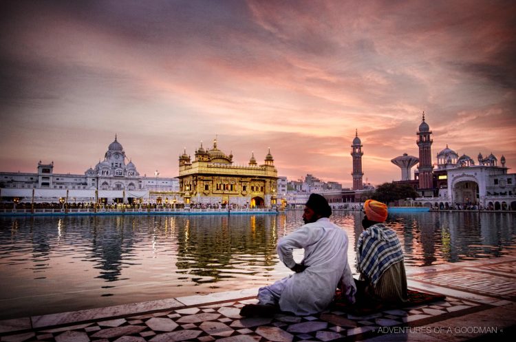 Two Seiks watch the sunrise over the Sri Harmandir Sahib at the Golden Temple in Amritsar, India