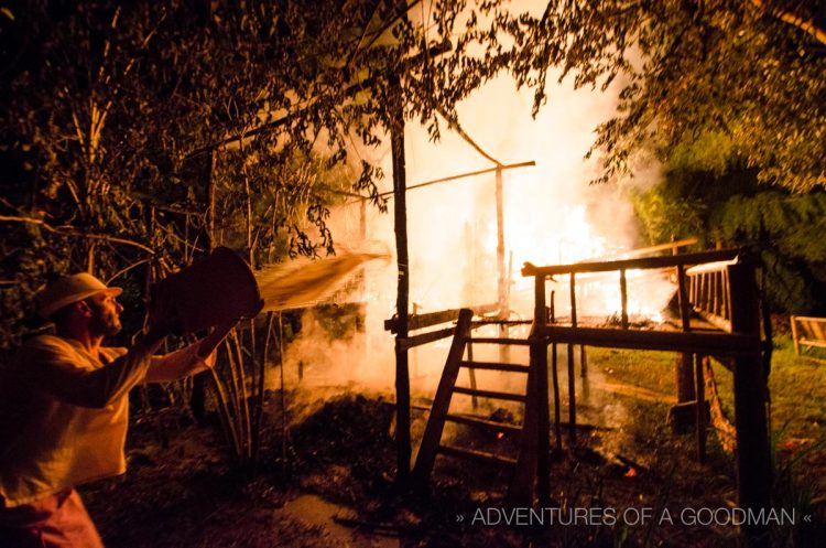 MadLove tosses a bucket of water on the fire in an unsuccessful attempt to put it out