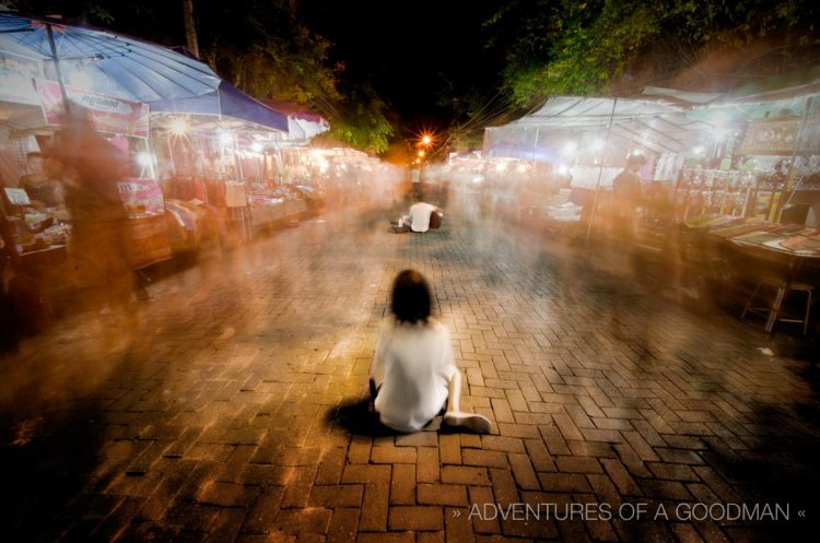 A 30 second exposure of a beggar in the Chiang Mai Sunday Walking Street Market ... notice how not a single person stops to give her any change