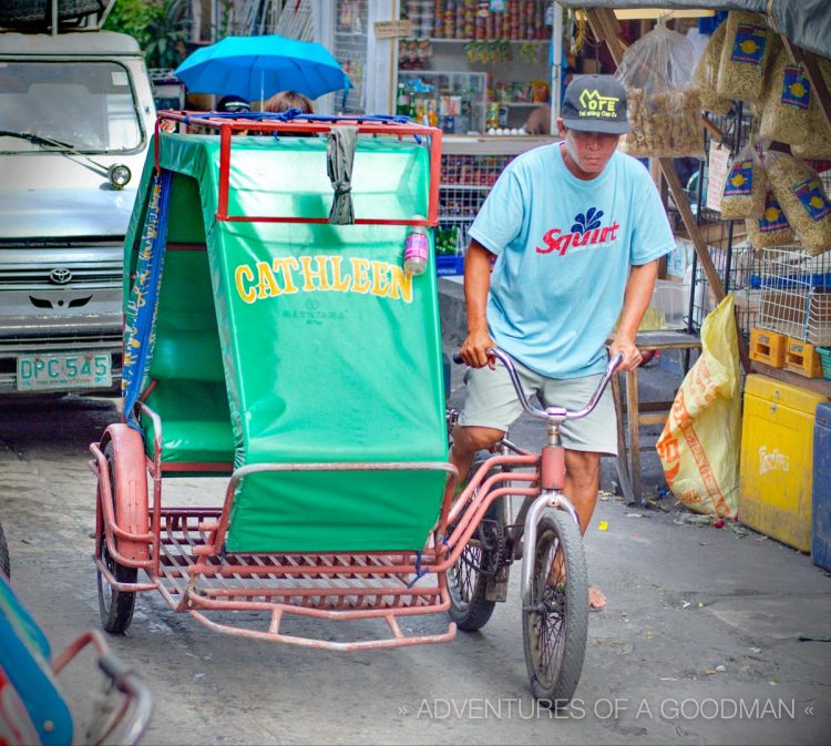 A pedicab makes its way through the busy streets of Manila, Philippines