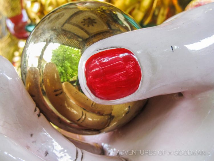 A reflecting ball in the hand of a statue at Phat Tich Temple in Vientiane, Laos