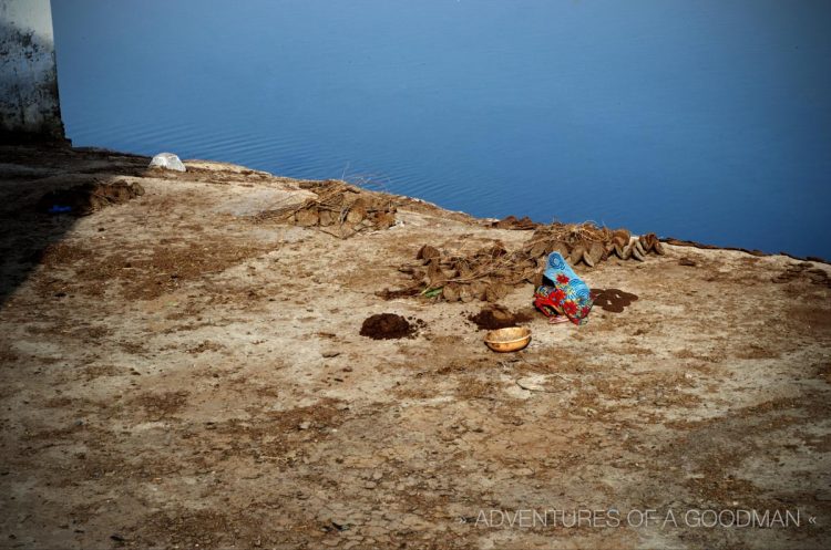 A woman makes cow dung patties on the Bank of the Yamuna River in Agra, India, next to Chini-Ka-Rauzah Tomb