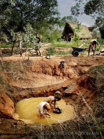 Cleaning off supplies after a dirty and muddy first work at Sadhana Forest in India