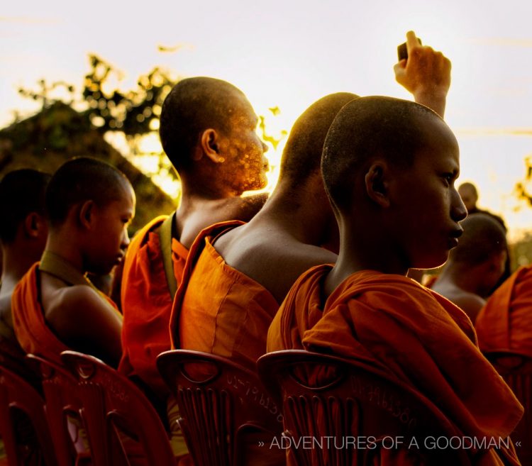 A monk gets the energy of a camera at sunrise - 12,999 monk alms procession in Chiang Mai, Thailand