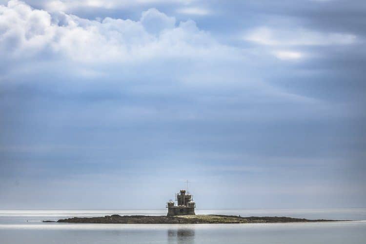 This is the Tower of Refuge seen from the shore of the Isle of Man. The structure was built upon a reef in 1832. When the tide is low the ruin can be reached by walking but with a high tide, when the reef is submerged, the tower appears like floating on the sea.