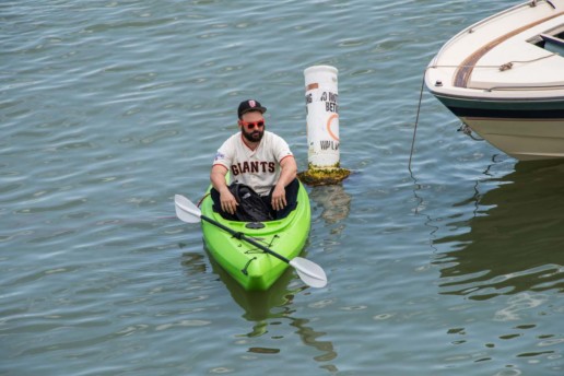 A fan waits in McCovey Cove for a player to hit a home run over the wall and into the water