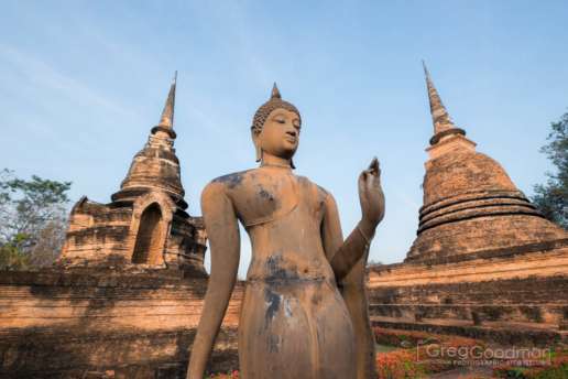 A reconstructed statue alongside the ruins of Wat Sa Sri in Sukhothai, Thailand